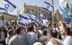 Israelis wave Zionist flags during a march, in Al-Quds,
